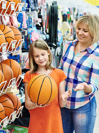 mother and daughter shopping for a basketball in a sporting goods store